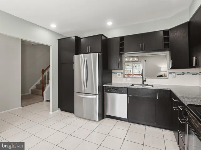 a kitchen with kitchen island a counter top space cabinets and stainless steel appliances