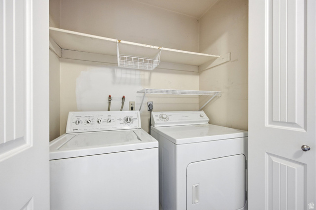 734 Sandy Dunes Drive Sandy, UT 84094 - Photo 23 of 36 Dedicated laundry area with a large landing for doing laundry, featuring a white top-load washer and front-load dryer