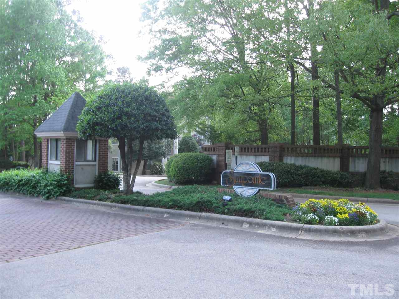 6111 Sunpointe Drive, Unit 201 Raleigh, NC 27606 - Photo 1 of 17 a front view of a house with a garden and trees