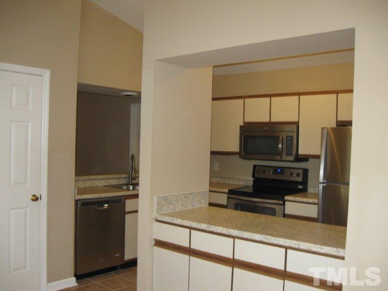 6111 Sunpointe Drive, Unit 201 Raleigh, NC 27606 - Photo 13 of 17 a living room with a stove and a refrigerator