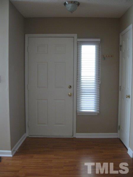 6111 Sunpointe Drive, Unit 201 Raleigh, NC 27606 - Photo 3 of 17 a view of an empty room with wooden floor and a window