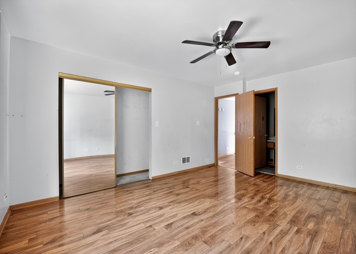 602 Merrill Avenue Calumet City, IL 60409 - Photo 20 of 22 a view of an empty room with wooden floor and a ceiling fan