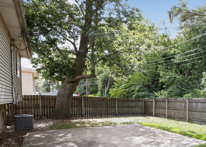 602 Merrill Avenue Calumet City, IL 60409 - Photo 6 of 22 a view of a backyard with a fence and large trees