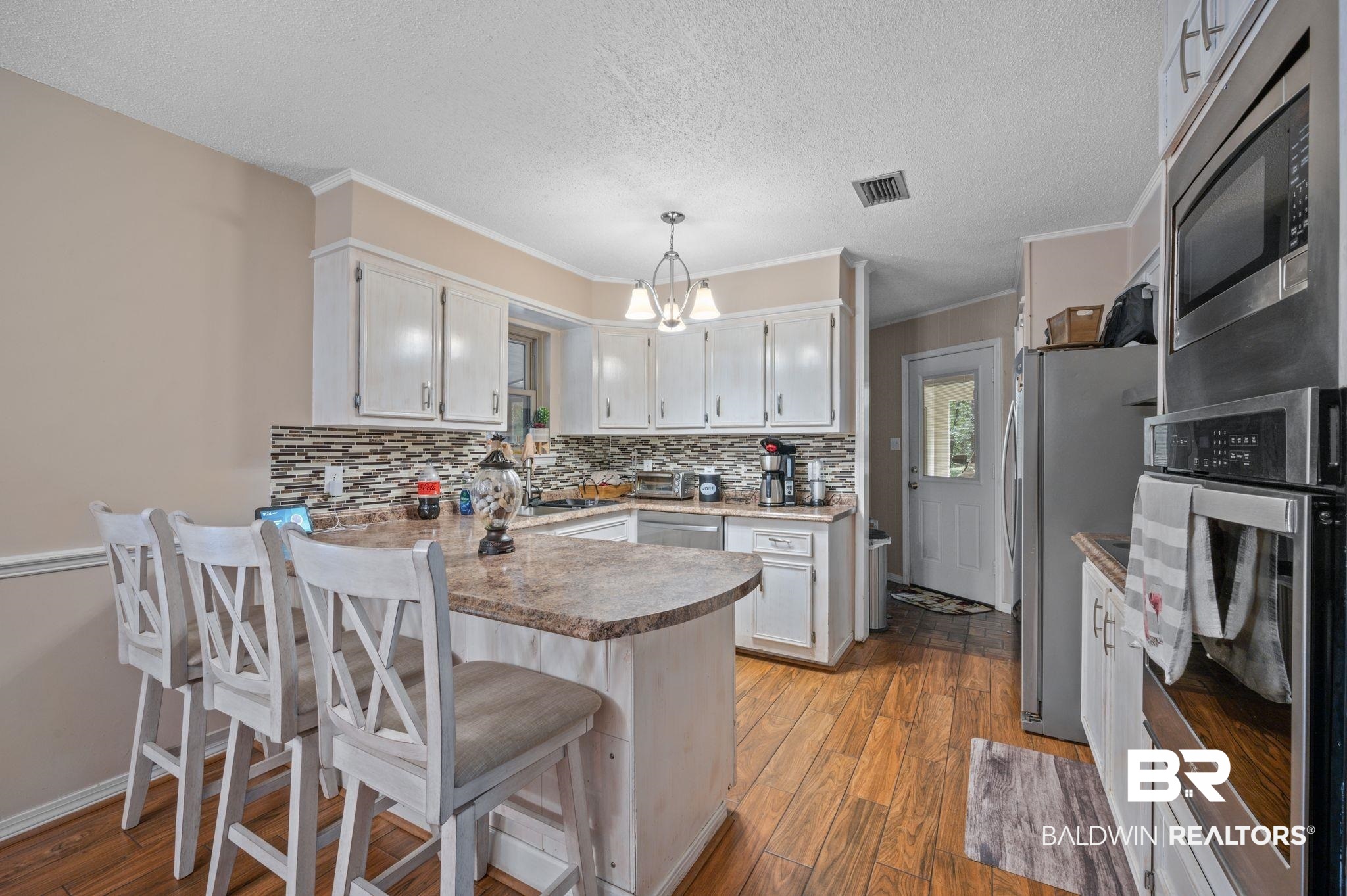 4566 McCrary Road, Unit A Semmes, AL 36575 - Photo 8 of 28 Kitchen with a chandelier, light hardwood / wood-style flooring, decorative light fixtures, kitchen peninsula, and appliances with stainless steel finishes