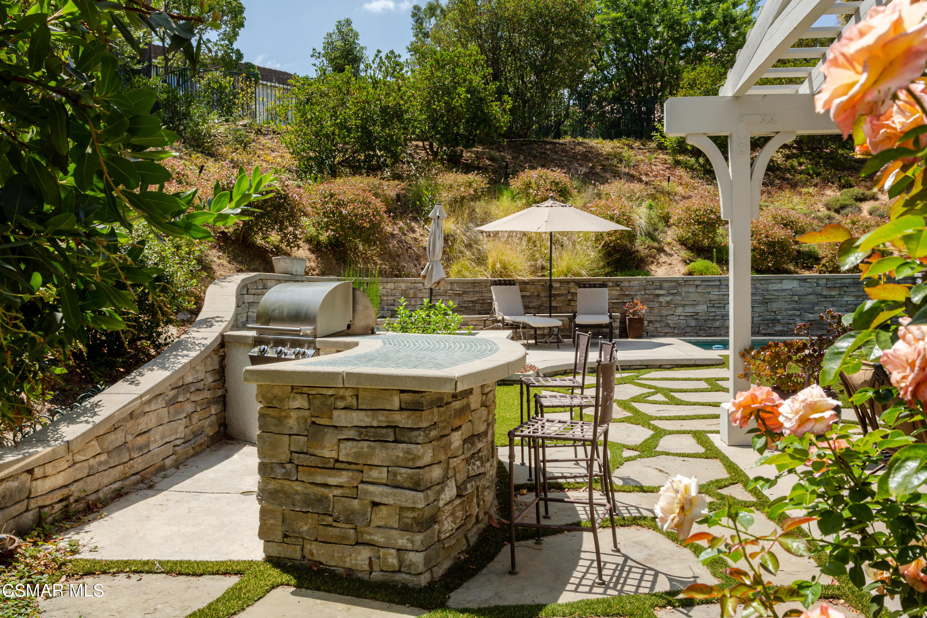 30 West Twisted Oak Drive Simi Valley, CA 93065 - Photo 36 of 45 a view of a patio with table and chairs under an umbrella with a small garden