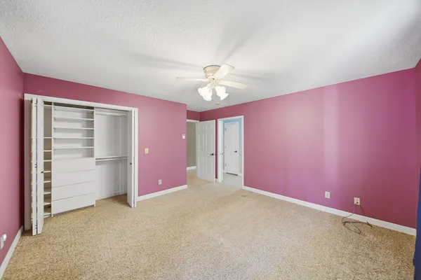 an empty room with closet and fan