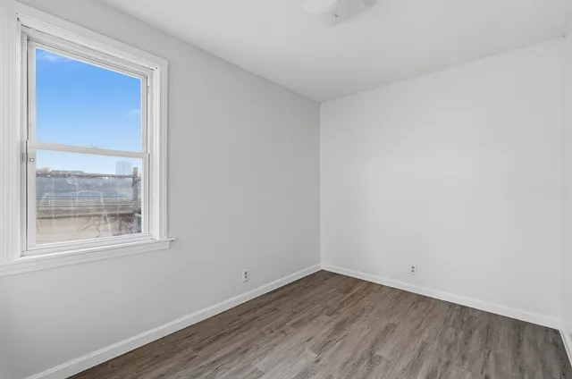 a view of a room that has wooden floor and a window
