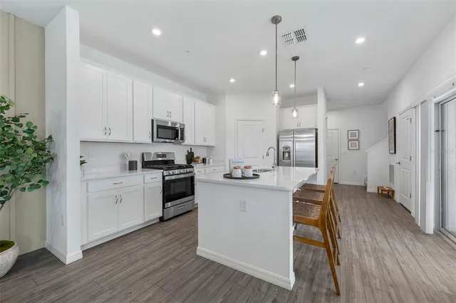 a kitchen with white cabinets and stainless steel appliances
