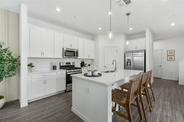 a kitchen with stainless steel appliances kitchen island granite countertop a sink and microwave