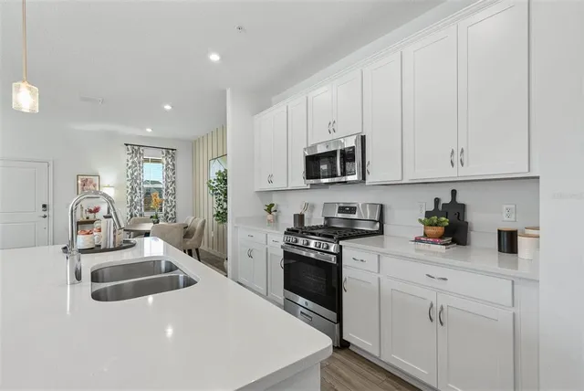 a kitchen with white cabinets and appliances