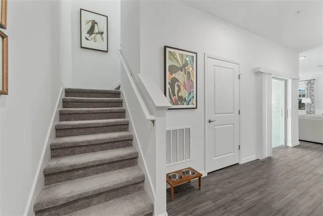 a view of a hallway with wooden floor and entryway