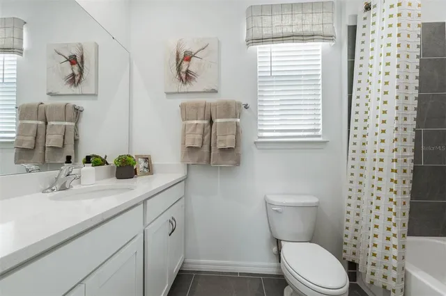 a bathroom with a granite countertop toilet sink and a window