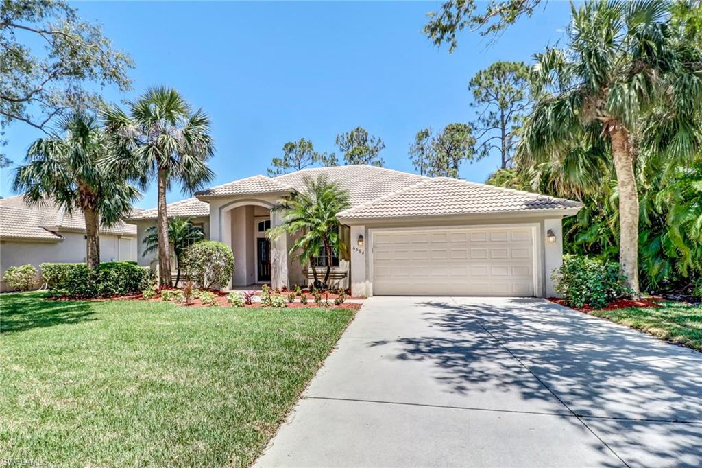 6564 Chestnut Circle Naples, FL 34109 - Photo 1 of 27 a front view of a house with garden