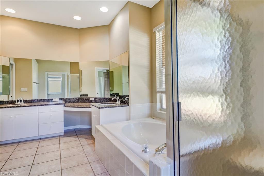 6564 Chestnut Circle Naples, FL 34109 - Photo 14 of 27 a bathroom with a granite countertop sink and bathtub