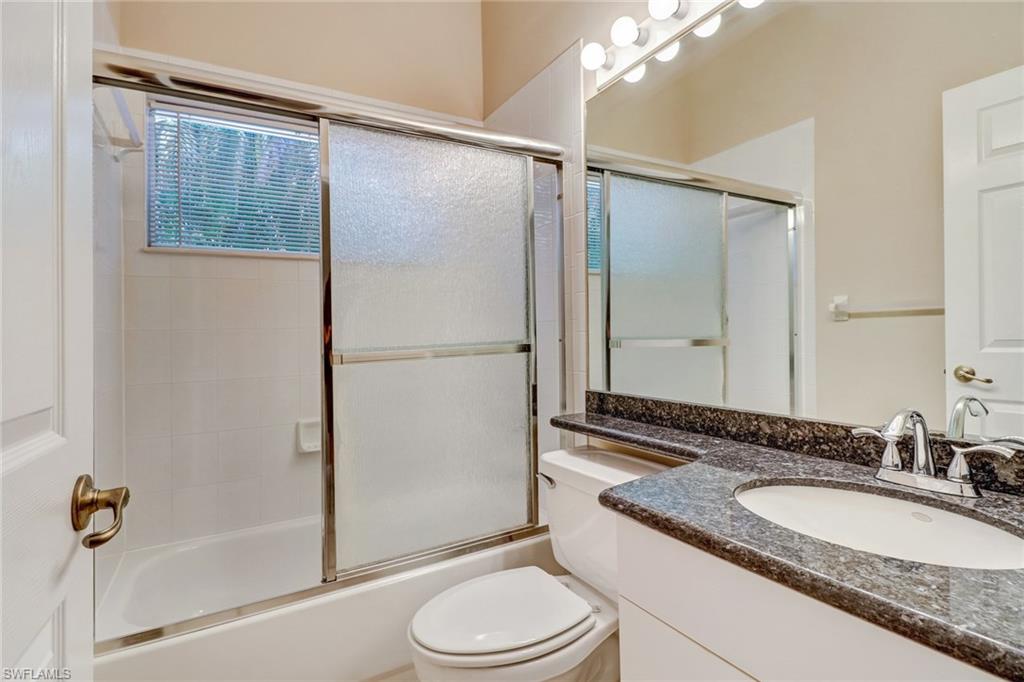6564 Chestnut Circle Naples, FL 34109 - Photo 18 of 27 a bathroom with a granite countertop sink toilet and shower