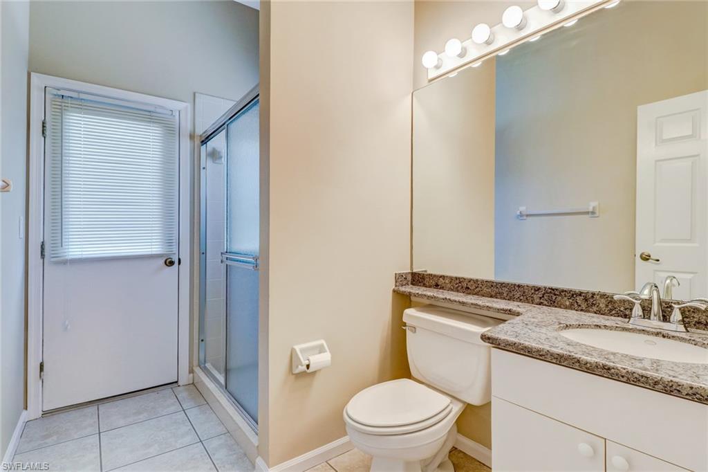 6564 Chestnut Circle Naples, FL 34109 - Photo 22 of 27 a bathroom with a granite countertop sink toilet and shower