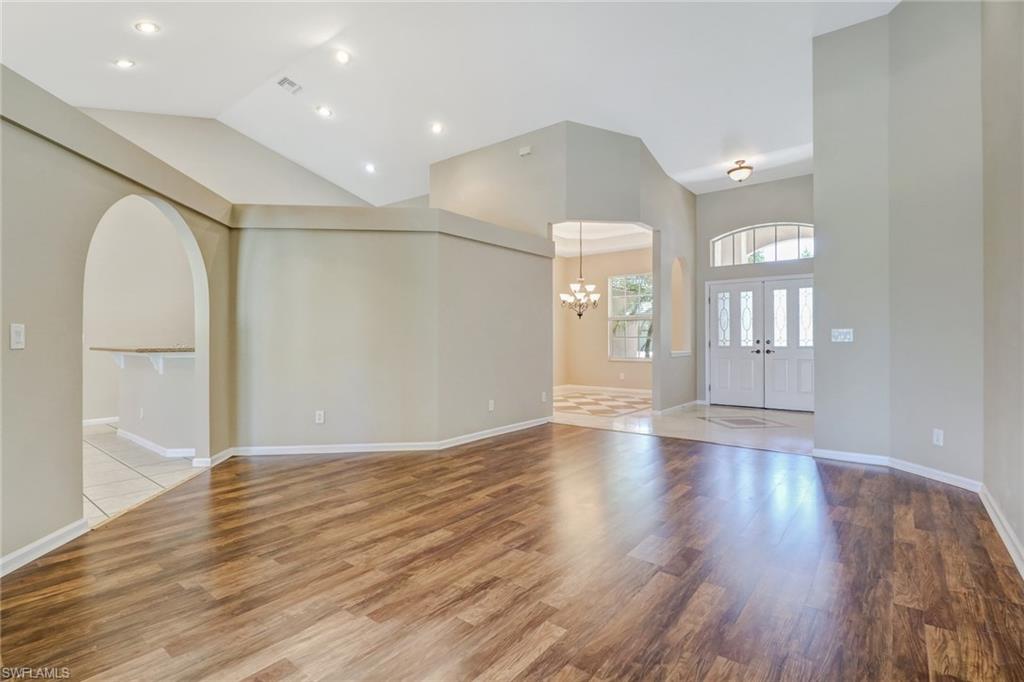 6564 Chestnut Circle Naples, FL 34109 - Photo 3 of 27 a view of an empty room with wooden floor and a window