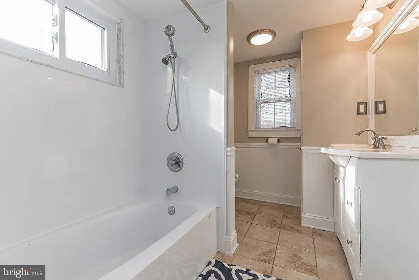 4090 Old Town Road Huntingtown, MD 20639 - Photo 11 of 20 a bathroom with a bathtub a shower a sink and a window