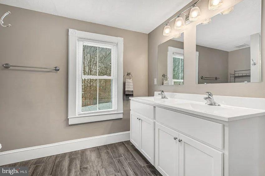 4090 Old Town Road Huntingtown, MD 20639 - Photo 12 of 20 a bathroom with a sink a mirror and a window