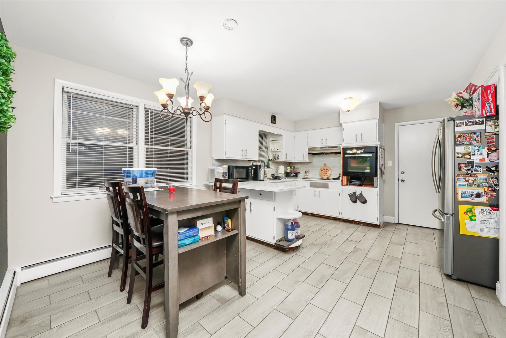 3543 West 57th Street Chicago, IL 60629 - Photo 19 of 43 a kitchen with stainless steel appliances kitchen island granite countertop a stove a refrigerator and a dining table with wooden floor