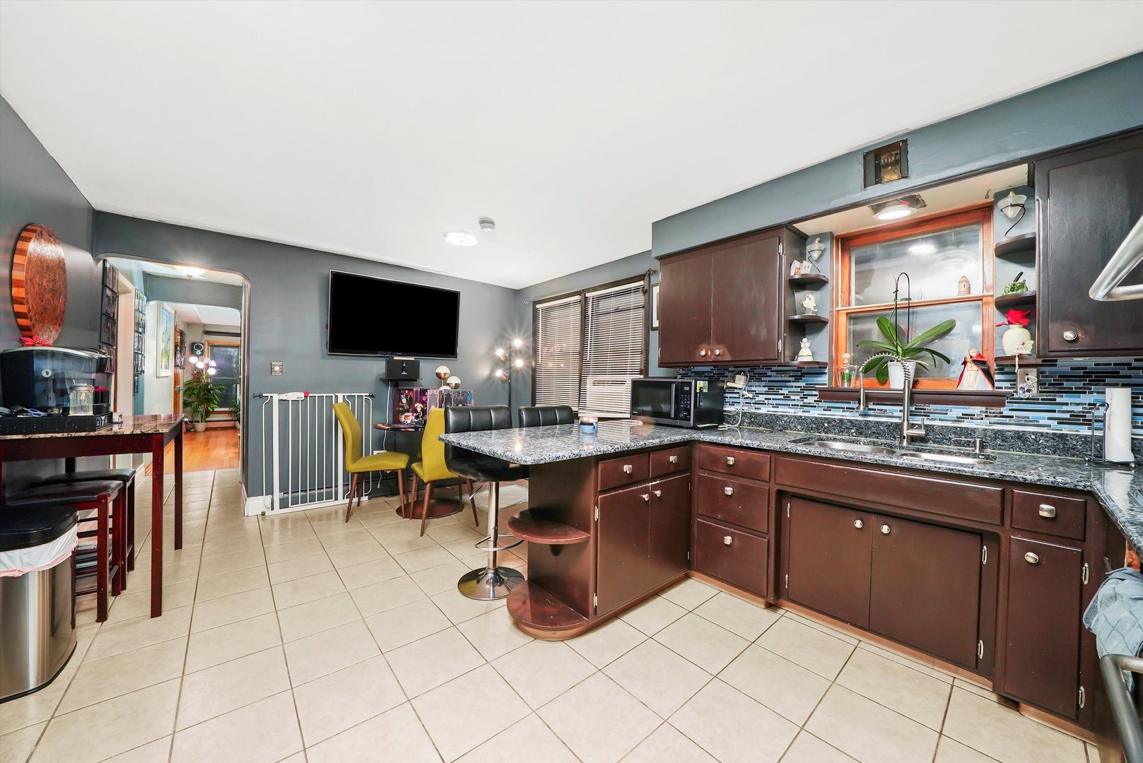 3543 West 57th Street Chicago, IL 60629 - Photo 9 of 43 a kitchen with stainless steel appliances kitchen island granite countertop a table and chairs in it