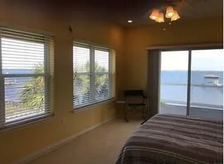 a bedroom with a bed and a large window