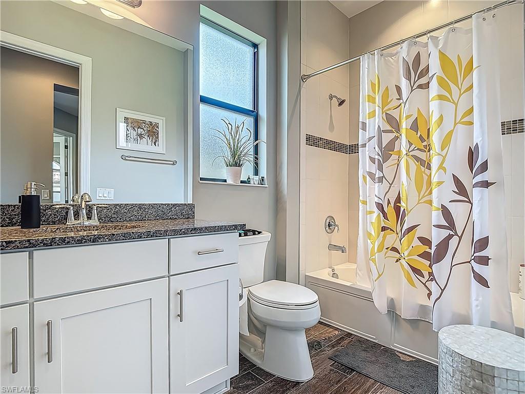 4524 Tamarind Way Naples, FL 34119 - Photo 24 of 50 Full bathroom with vanity, toilet, shower / bath combo with shower curtain, and wood finished floors