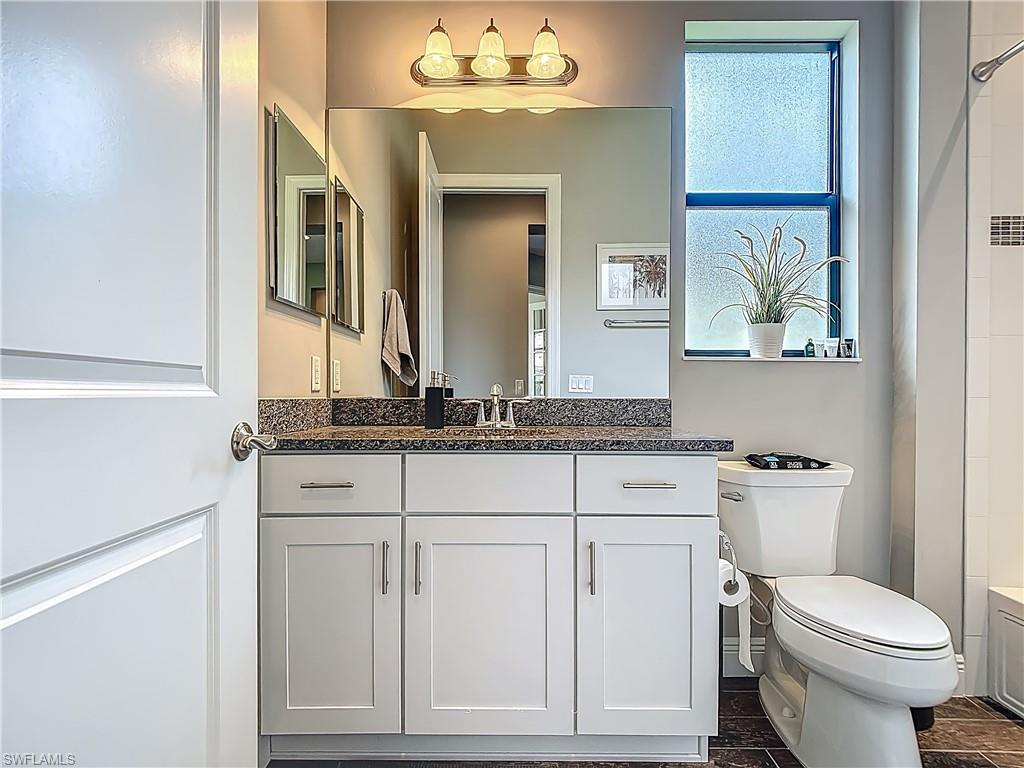 4524 Tamarind Way Naples, FL 34119 - Photo 25 of 50 Bathroom with toilet, vanity, and a shower