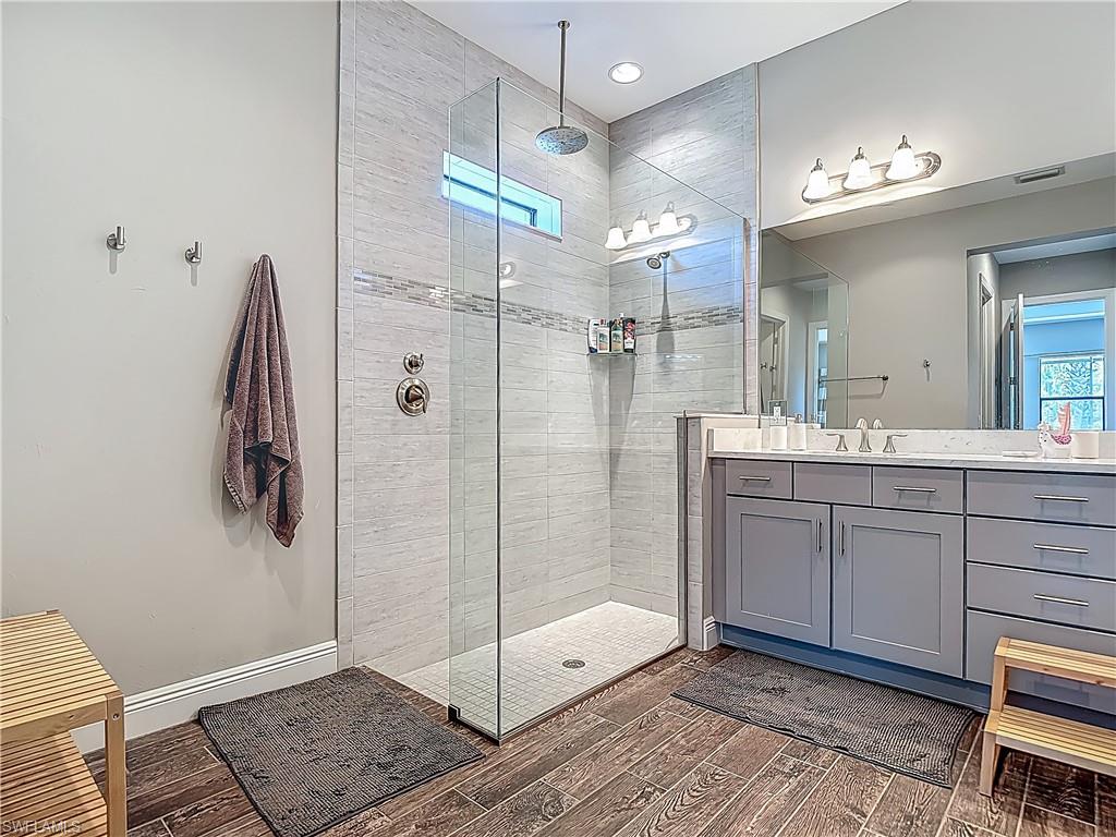 4524 Tamarind Way Naples, FL 34119 - Photo 32 of 50 Full bath featuring vanity, wood finished floors, a tile shower, and recessed lighting