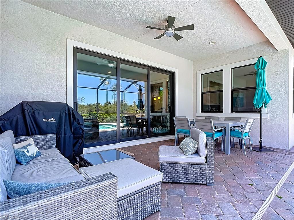 4524 Tamarind Way Naples, FL 34119 - Photo 38 of 50 View of patio / terrace with outdoor dining area, a ceiling fan, a pool, and an outdoor living space