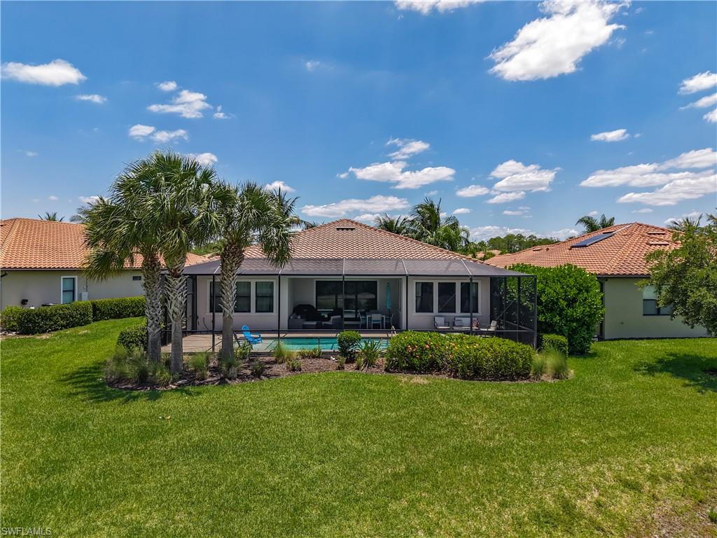 4524 Tamarind Way Naples, FL 34119 - Photo 44 of 50 Back of house with a yard, a tiled roof, an outdoor pool, and a patio