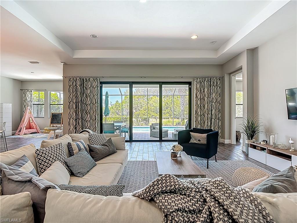 4524 Tamarind Way Naples, FL 34119 - Photo 5 of 50 Living area featuring wood finished floors, a tray ceiling, recessed lighting, and baseboards