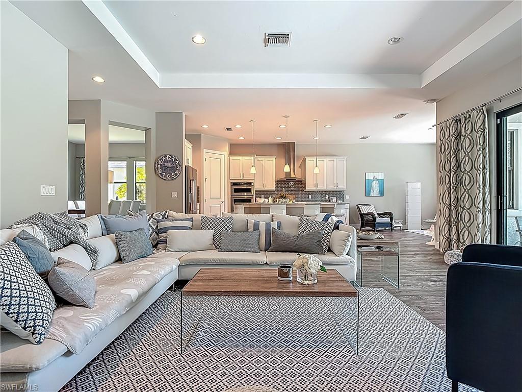 4524 Tamarind Way Naples, FL 34119 - Photo 7 of 50 Living area featuring recessed lighting, wood finished floors, and a tray ceiling