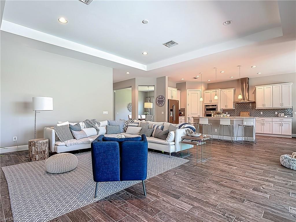 4524 Tamarind Way Naples, FL 34119 - Photo 8 of 50 Living room with a tray ceiling, dark wood-style floors, recessed lighting, and baseboards