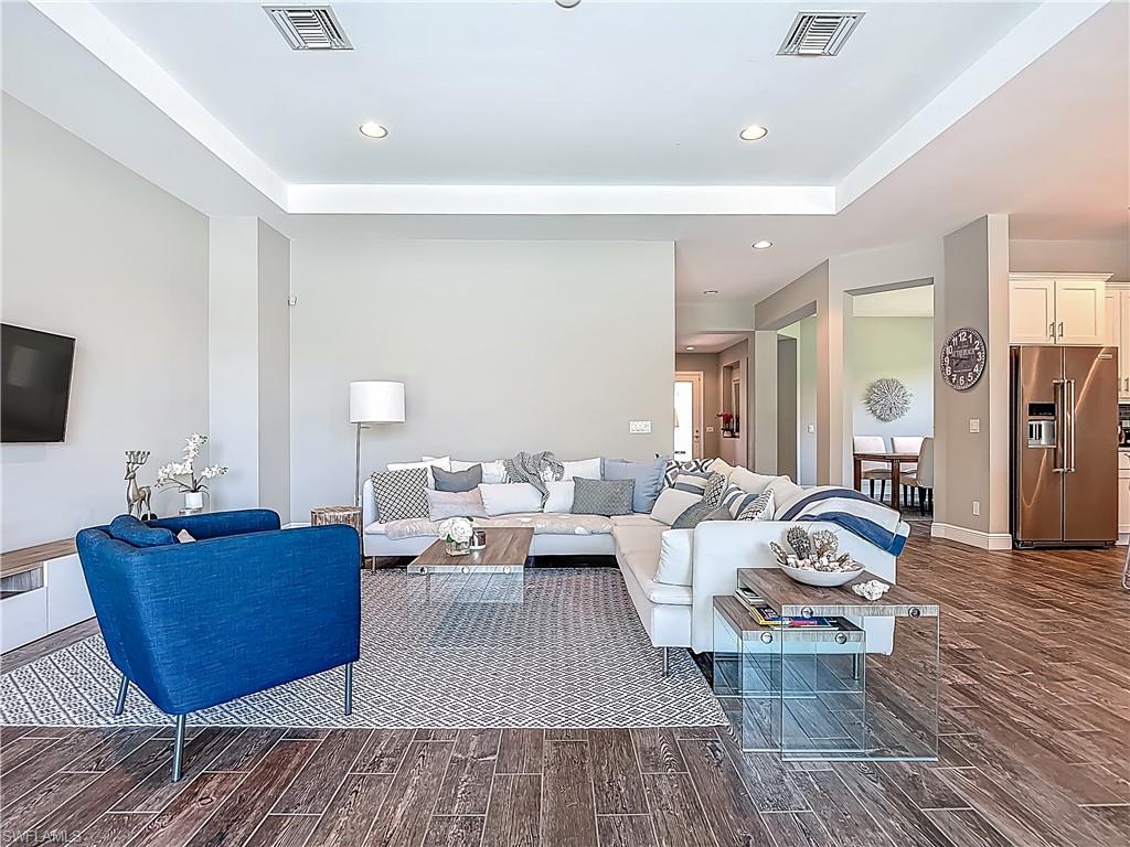 4524 Tamarind Way Naples, FL 34119 - Photo 9 of 50 Living area featuring dark wood-style flooring, a raised ceiling, recessed lighting, and baseboards