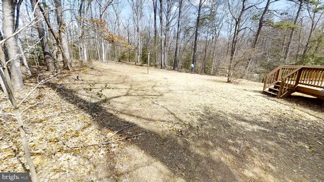 a view of a yard with wooden fence and trees