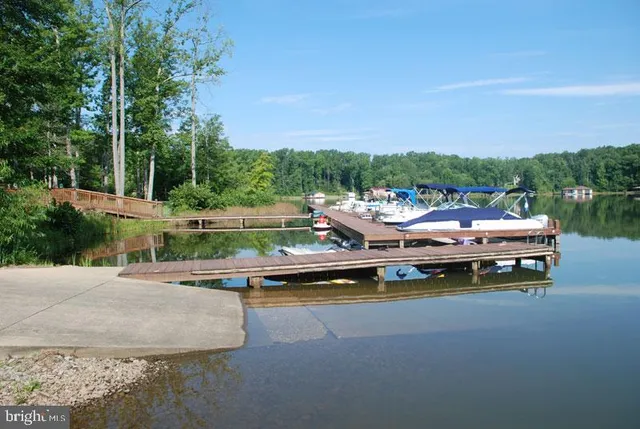 a view of swimming pool with seating area and trees in the background