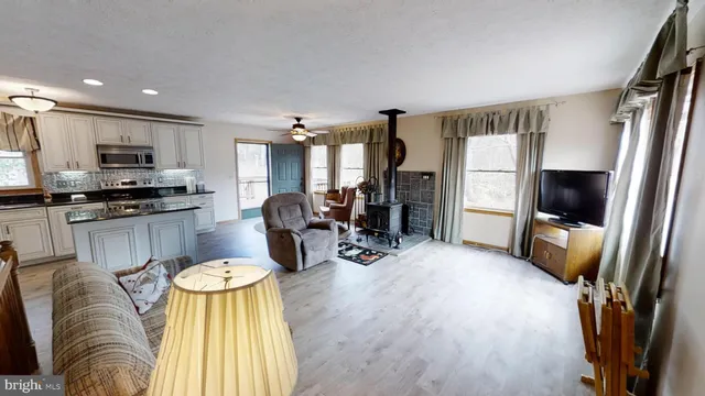 a living room with stainless steel appliances furniture and a flat screen tv