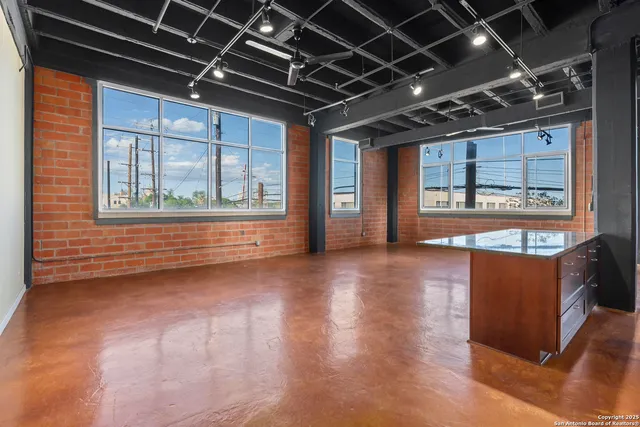 a view of a livingroom with wooden floor and windows
