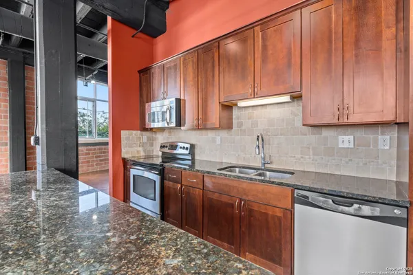 a kitchen with stainless steel appliances granite countertop a sink stove and cabinets