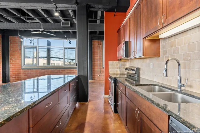a kitchen with stainless steel appliances granite countertop a sink and a wooden cabinets