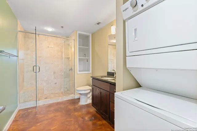 a bathroom with a granite countertop sink a toilet and shower