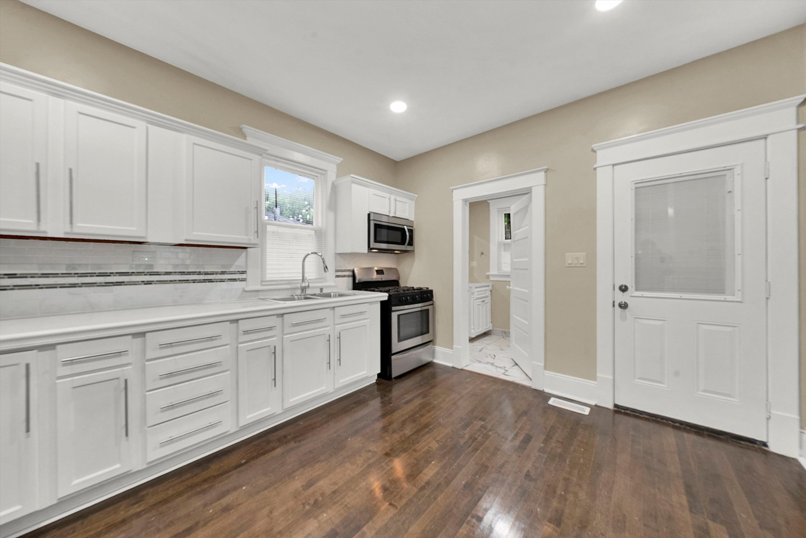 325 4th Street Waukegan, IL 60085 - Photo 15 of 34 a kitchen with granite countertop white cabinets and white appliances