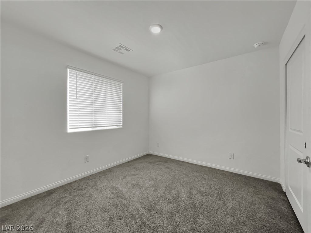 9984 Indigo Cliffs Street Las Vegas, NV 89141 - Photo 22 of 31 Empty room featuring baseboards, visible vents, and dark carpet