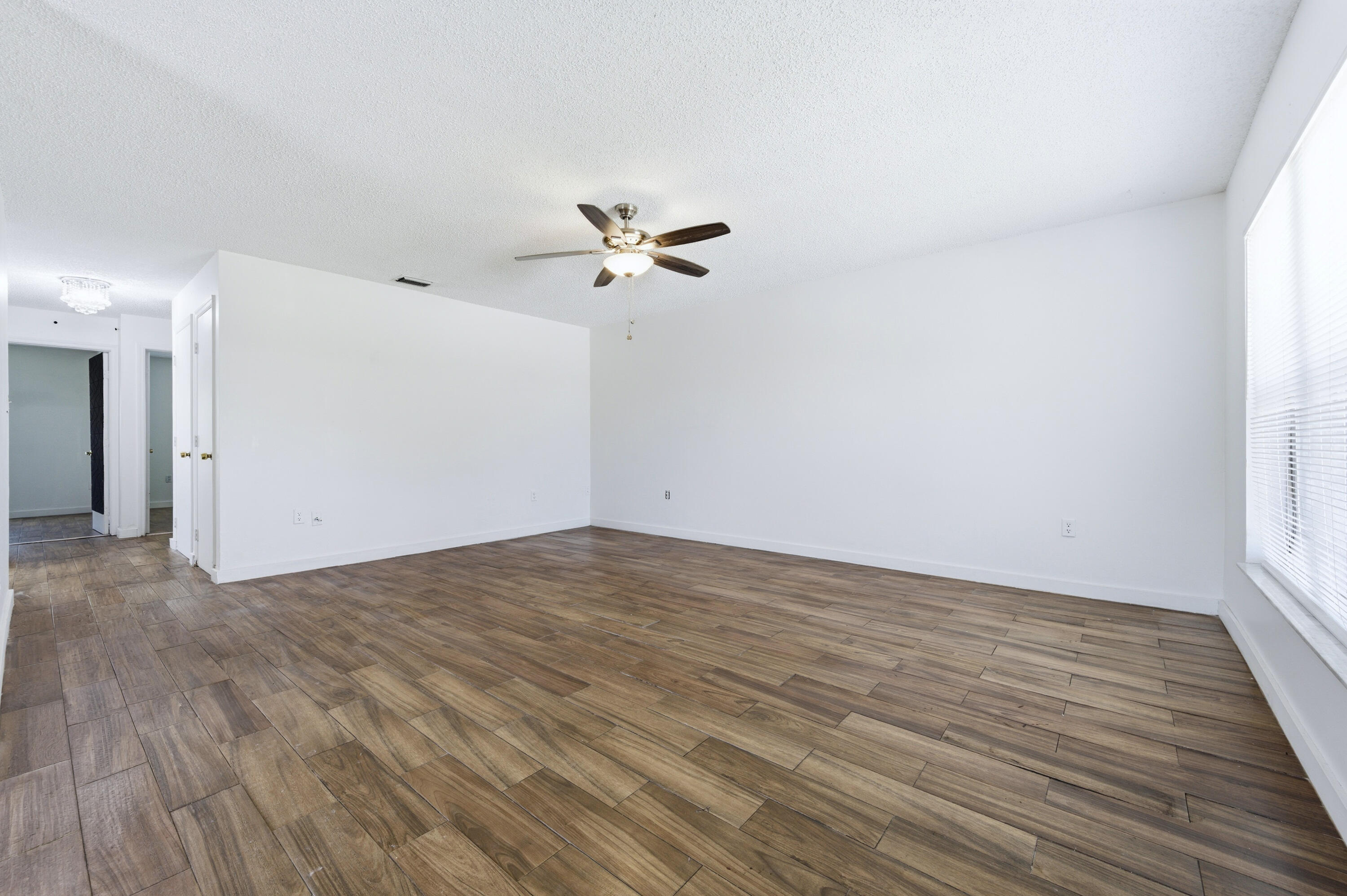 6088 Heather Street Jupiter, FL 33458 - Photo 3 of 18 a view of a room with wooden floor and a ceiling fan