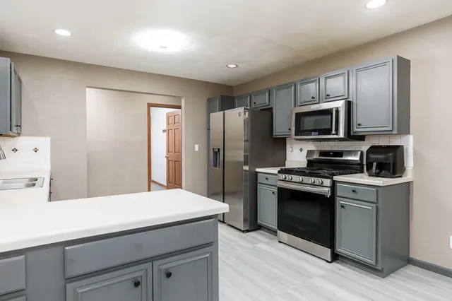 a kitchen with kitchen island a sink stainless steel appliances and cabinets