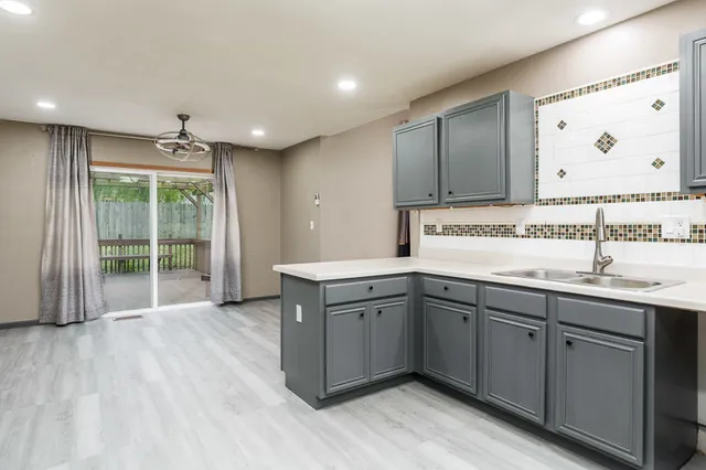 a kitchen with sink cabinets and wooden floor