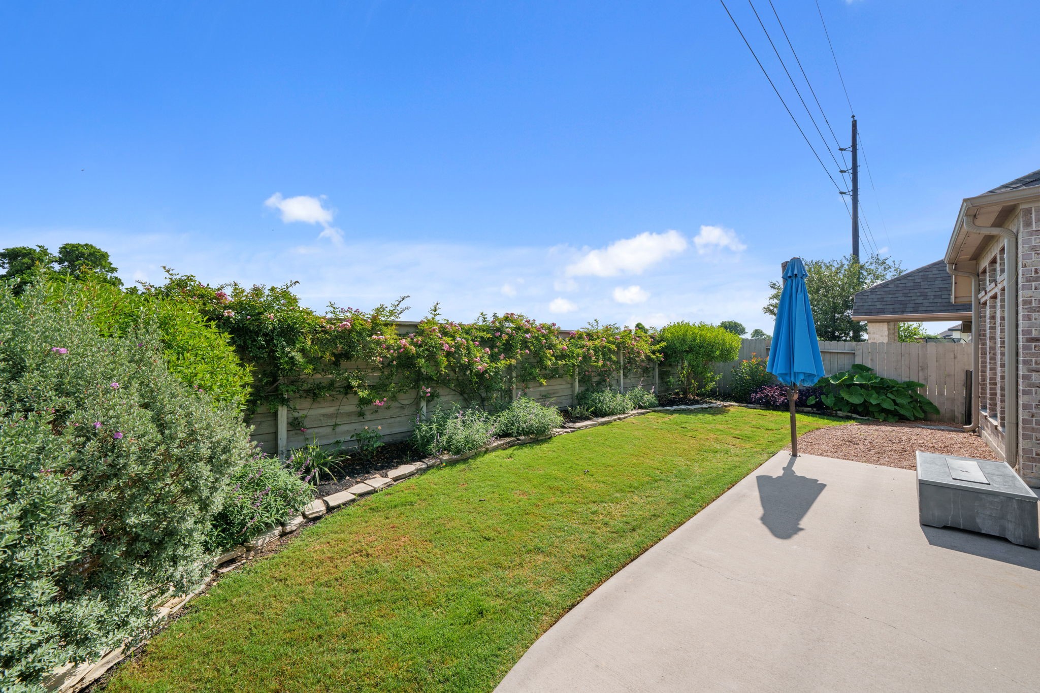 2119 Blackhawk Ridge Lane Manvel, TX 77578 - Photo 35 of 49 Lush, low-maintenance backyard showcasing beautifully landscaped garden beds along the fence line. A true private retreat with no back neighbors — just open sky and serene natural beauty.