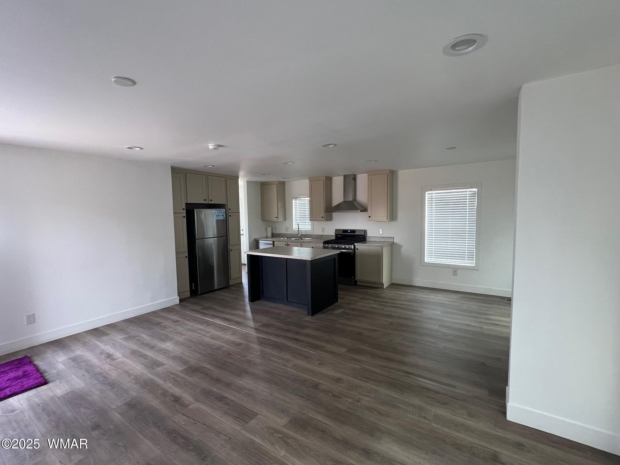 4129 Apache Road Snowflake, AZ 85937 - Photo 10 of 48 a large kitchen with kitchen island granite countertop wooden floors and stainless steel appliances