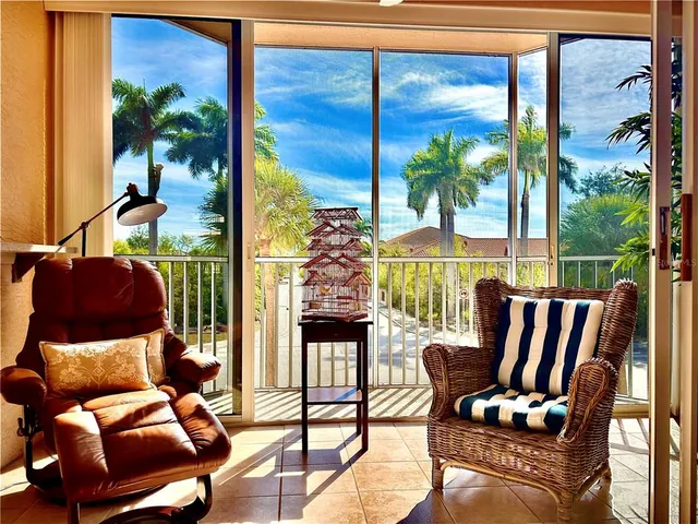 a living room with patio furniture and a potted plant